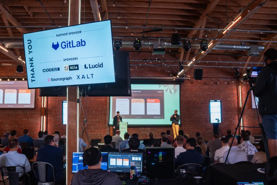 Thank-you screen naming the summit sponsors, GitLab and XALT among them, above the stage and the audience