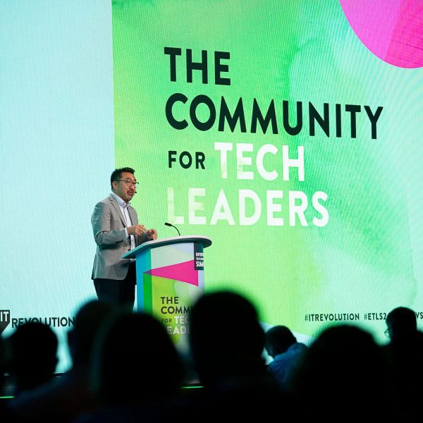 Gene Kim speaking at a lectern in front of an audience